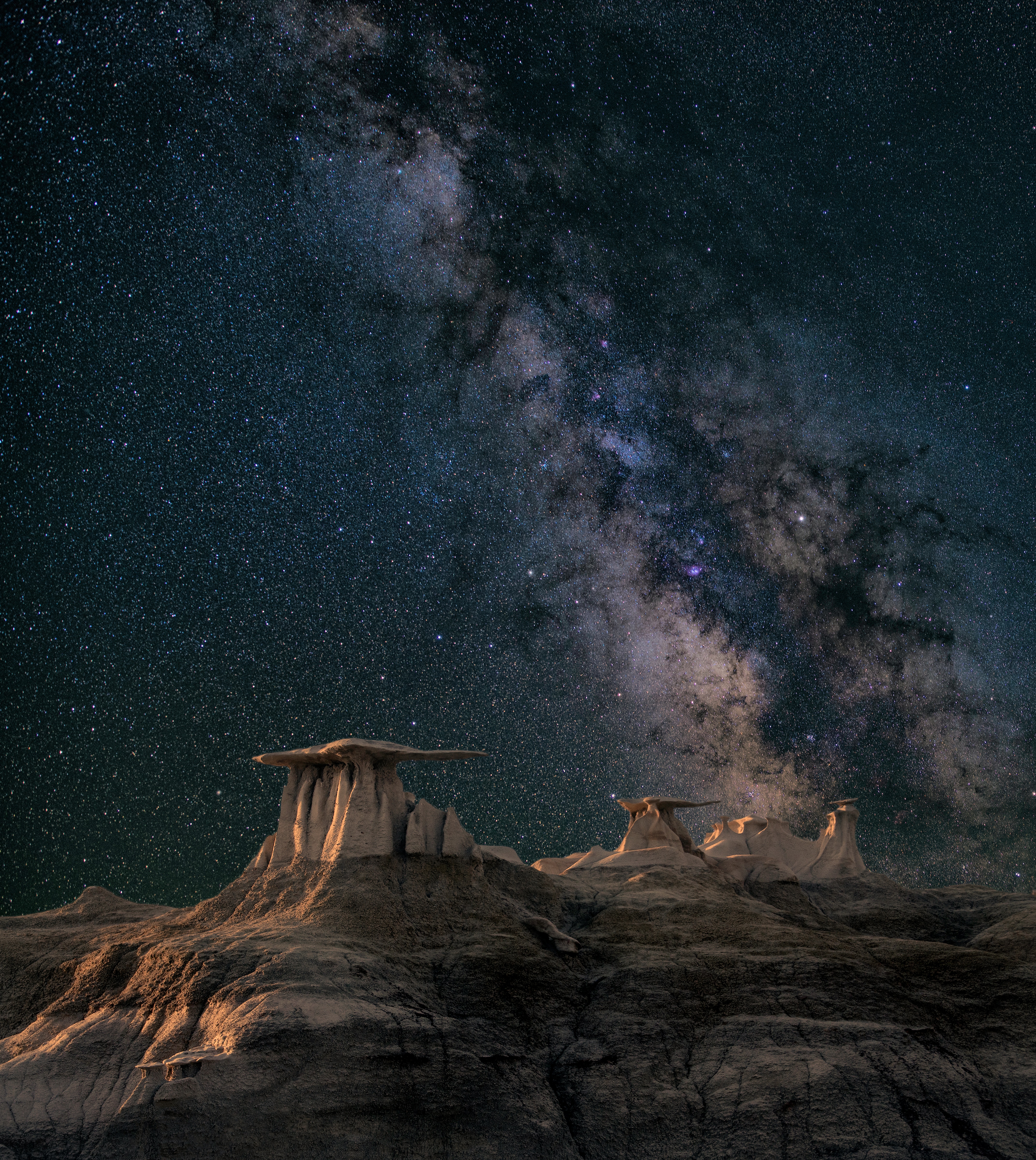 The Milky Way in a clear and starry night sky above unusual rock formations.