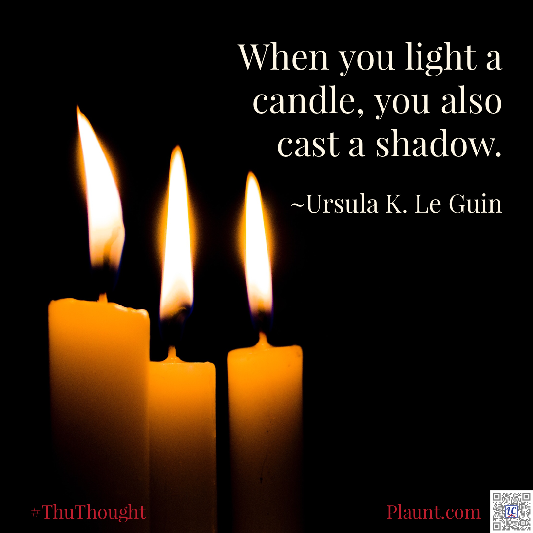 Three lit taper candles against a dark background. Caption: When you light a candle, you also cast a shadow. ~Ursula K. LeGuin
